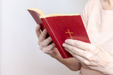 Yaşlı kadın elinde eski bir kutsal incili tutuyor, Yaşlı kadın Yeni Ahit 'i tutuyor ve dua ediyor.