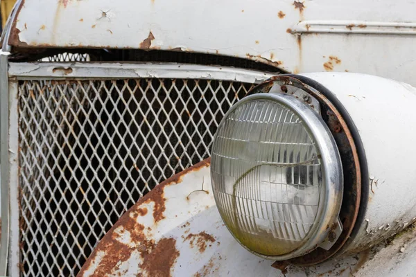 Headlight of an old rusty abandoned car, utilisation and scrap concept — Stock Photo, Image