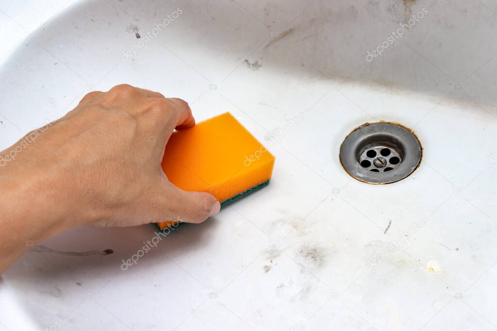 Concept of cleaning old dirty washbasin with rust stains, limescale and soap stains in the bathroom