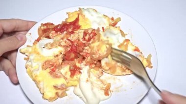 Omlet yiyen bir kadın, çırpılmış yumurta, kızarmış domates ve soğan yakın plan.