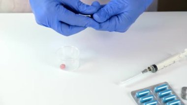 Mavi lateks eldivenli doktor ya da hemşire plastik ölçü kabına hap koyup hastaya veriyor, hastalık tedavisi ve reçete kavramı, ilaç dozajı