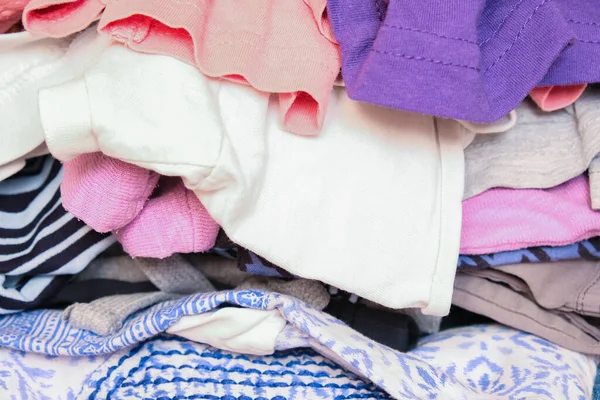 Unorganized heaps of clothes of different colors in a wardrobe lying in mess close up — Stock Photo, Image