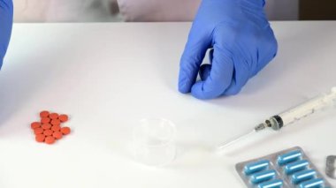 Mavi lateks eldivenli doktor ya da hemşire hastaya ilaç veriyor ve bir konteynır veriyor. Yakın görüş, hastalık tedavisi ve reçete kavramı çevrede tıbbi malzemeler var.