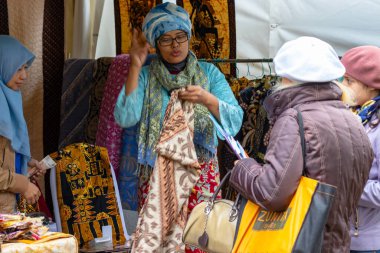 Yogyakarta, Endonezya - 02 Ağustos 2019: Kadın çeşitli batik kumaş, textyle satıyor. Geleneksel renkli Endonezya elbisesi pazarda satılıyor