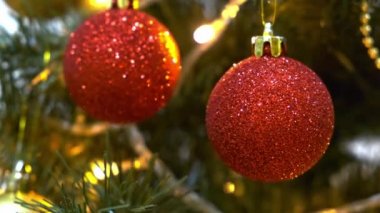 Kırmızı Noel toplarıyla süslenmiş Noel ağacı, bir elektrikli çelenk parıldıyor ve yanıp sönüyor, yeni yıl ve yılbaşı geleneği