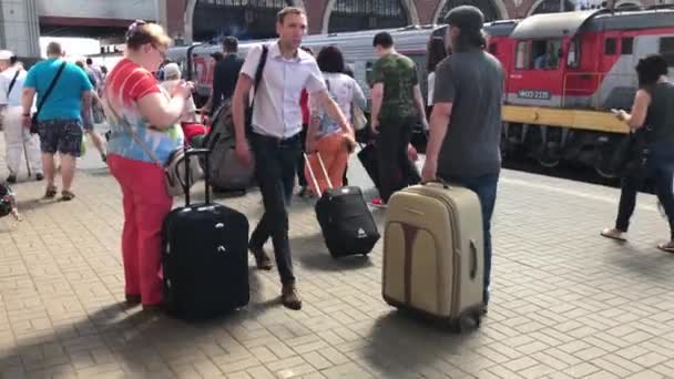 Moskva, Ryssland - 15 juni 2019: Moskvas passagerarplattform Kazanskijs järnvägsterminal, passagerare med bagageväskor som kör längs plattformen — Stockvideo