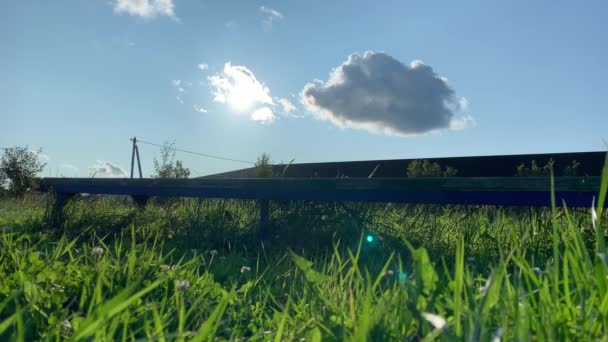 Triste mujer de ensueño sentada en un banco en un pueblo, en el campo. Día soleado de verano, follaje verde por todas partes y rayos de sol brillando en una cámara — Vídeos de Stock