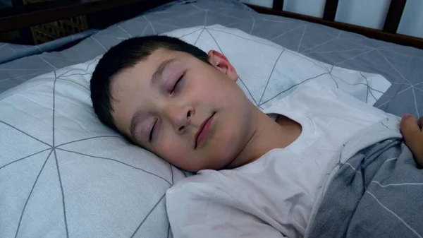一个男孩晚上躺在床上 从一边到另一边转过头去睡觉 想睡觉 睡不着觉和失眠 — 图库照片