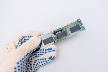 A hand of a repairer technician holding RAM, random access memory in order to upgrade an old computer against whote background, maintanance and repair concept. clipart