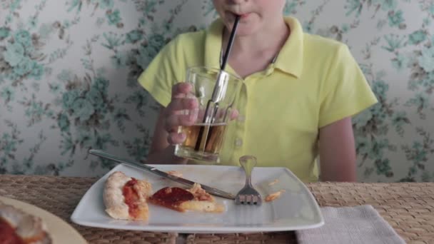 ガラスの藁でジュースを飲み レストランでおいしいイタリアのピザを食べる喉の渇きを癒す少年 — ストック動画