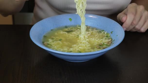 Γυναίκα Κάθεται Δίπλα Στο Τραπέζι Και Τρώει Στιγμιαία Ζυμαρικά Chopsticks — Αρχείο Βίντεο
