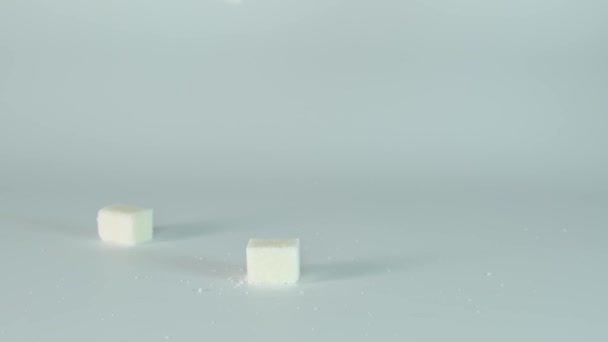 Cubos de azúcar, grumos cayendo sobre fondo blanco, cámara súper lenta, lentitud — Vídeos de Stock