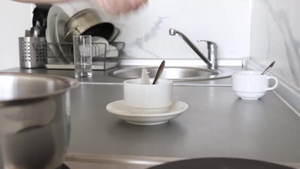 Manos haciendo té en una taza de cerámica blanca en la cocina por la mañana, té de hierbas frescas para el desayuno — Vídeos de Stock