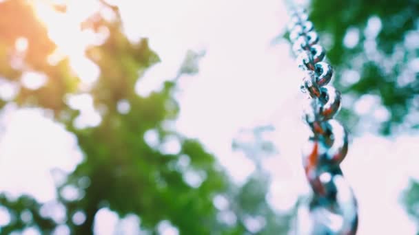 Cadena de acero resistente que conduce al cielo sobre un fondo de naturaleza verde — Vídeos de Stock