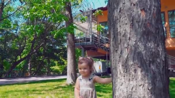 Unga far med barn som springer runt ett träd nära hus rostuschego, Pappa, son och baby dotter ha roligt på bakgården — Stockvideo