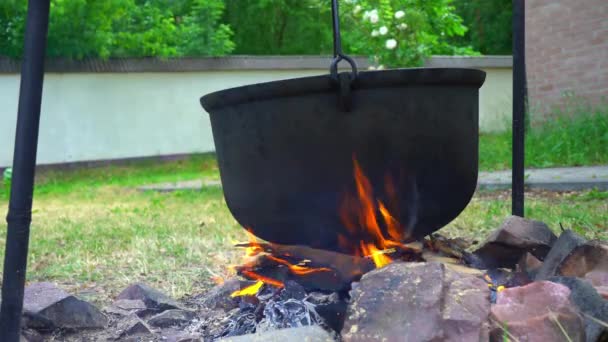 Konyha a szabadban, főzés a máglyán, a tűz, fém üst közelről — Stock videók