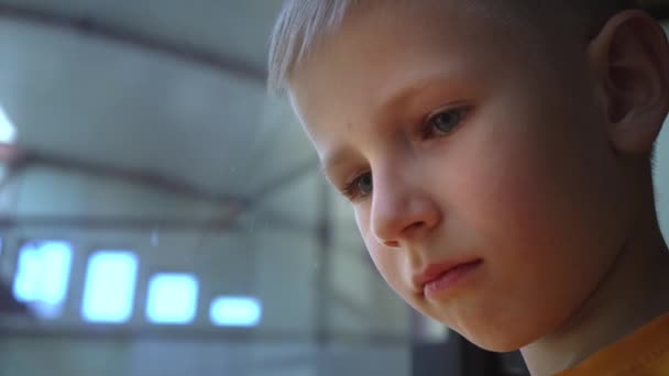 Ett barn med mycket sorgsna ögon ser ut någon på flygplatsen, en närbild porträtt av en pojke, childrens brutna förhoppningar — Stockvideo