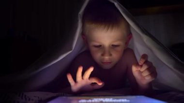 Tablet bilgisayar oyunu oynamak genç bir sarışın çocuğun kapsar.