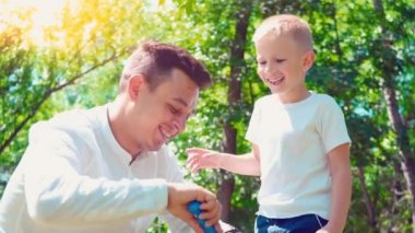 Babası onun oğlu üfleme sabunla kabarcıklar, eğlenceli aile eğlence, bir çocuk babası ile eğleniyor