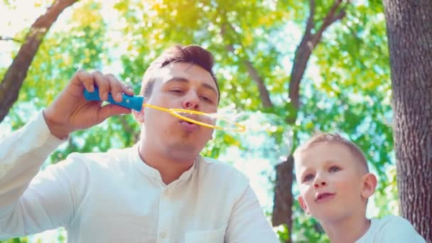 Babası onun oğlu üfleme sabunla kabarcıklar, eğlenceli aile eğlence, bir çocuk babası ile eğleniyor — Stok video