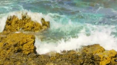 Kayalık sahil. Dalgalar sahil üzerinde rulo ve kayalara karşı kesin. Gelgit