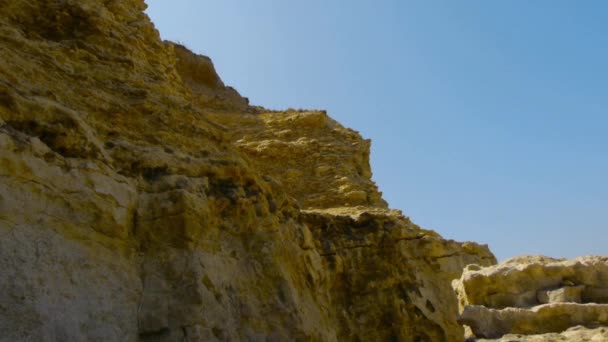 Rotsachtige kust tegen de blauwe hemel — Stockvideo