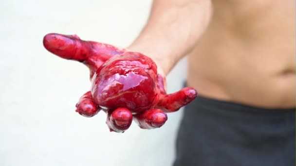 A mans hand bezit een bloedend hart op een witte achtergrond — Stockvideo
