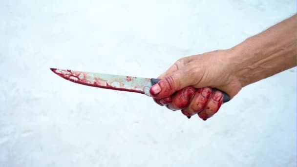 Mano e coltello nel sangue su sfondo bianco, mano maschile con un coltello insanguinato — Video Stock