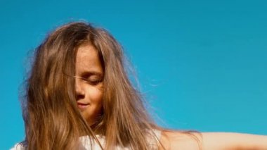 Mavi gökyüzü, çocuk hayalleri karşı kapalı gözlerle uzun saçlı küçük bir kız portresi