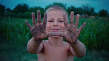 Mutlu bir çocuğun elleri kirli yere kadar gösterir bir çocuk bir neşeli çocukluk eğlence çamura bulaşmış
