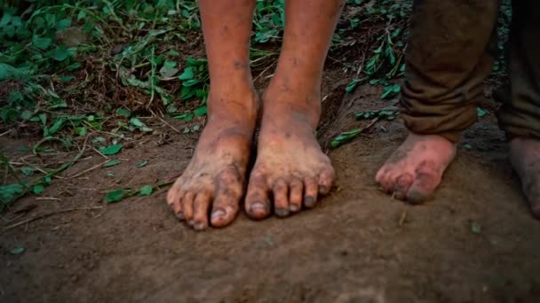 Primo piano piedi nudi piedi sporchi di un bambino in piedi su un terreno umido — Video Stock