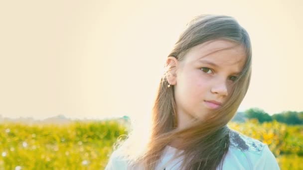 Portrét atraktivní holčička s velkýma hnědýma očima na pozadí přírody s vývojem vlasy — Stock video