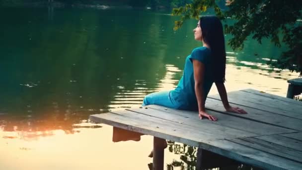 Egy fiatal nő ellazítja a tó közelében — Stock videók