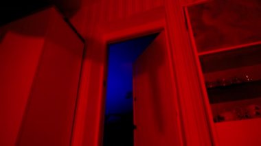 Katil elinde bir bıçak tutuyor. Cinayet. Duvardaki suçlunun gölgesi. Halloween. Oda kırmızı ışıkla doldu. Bir korku filminden bir sahne. Gerilim. Katil.