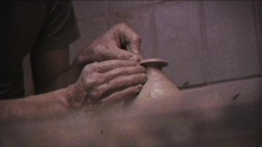 Bağbozumu etkisi. Çömlekçi bir sürahi kil yapar. Aile video arşivi. Geçmişe dönüş. Kamera 8mm. Eski film. Seramistim. Adamın biri çömlekçi çarkında vazo yapıyor. El işi. Çömlek. Çamur tabakları