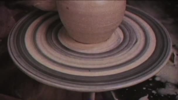复古效果 陶工用黏土做了一壶 家庭视频档案 8毫米摄像机 老电影 陶瓷师 一个人在陶工的轮子上做一个花瓶 手工劳动 粘土盘 — 图库视频影像