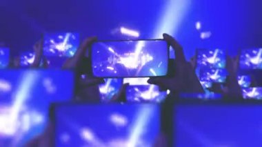 Kalabalık bir konser izliyor, şarkı söylüyor, zıplıyor. Konser sırasında havada yüzen altın konfetileri. Hayranlar akıllı telefonlardan video kaydediyor. Bir sürü akıllı telefon. Canlı yayın. Hikayeler. Çarpıcı sahne ışığı