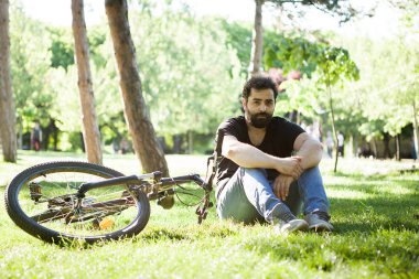 Sakallı adam rahatlatıcı parkta çim