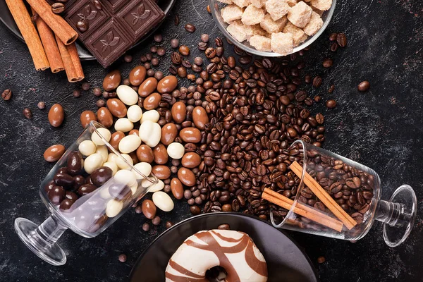 Kahve çekirdekleri ve çikolata fıstık ile dökülen gözlük — Stok fotoğraf
