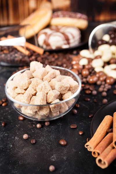 Kahverengi şeker bir cam kase yanında şeker ve tatlılar — Stok fotoğraf