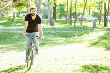 Bisiklet süren genç adam.