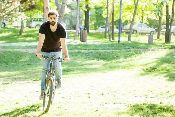 Bisiklet süren genç adam.