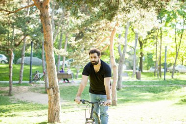 Bisiklet süren genç adam.