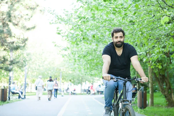 Jeune homme barbu en vélo dans le parc — Photo