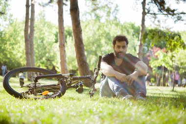 Onun yanında onun bisiklet ile kameraya bakan adam