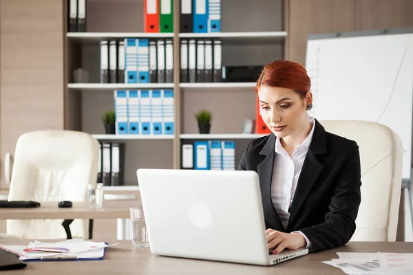 Businesswoman in formal suit working at a laptop — Stock Photo, Image