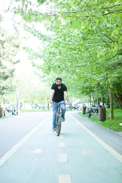 Jeune homme barbu en vélo dans le parc — Photo