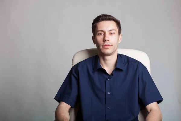Retrato de un joven hombre de negocios con camisa casual sentado en una silla —  Fotos de Stock