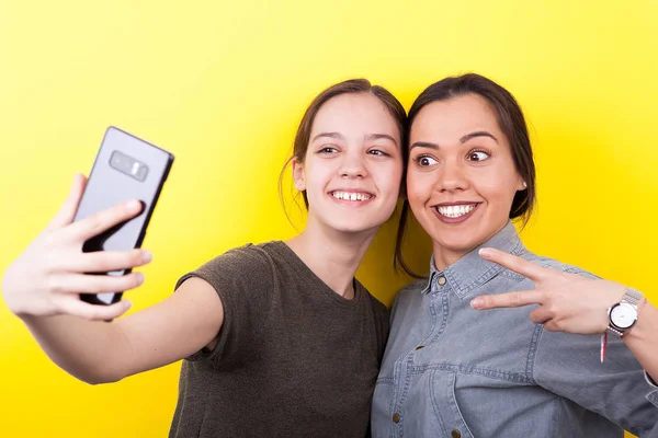 Joyeux rire et sourire sœurs prendre un selfie — Photo