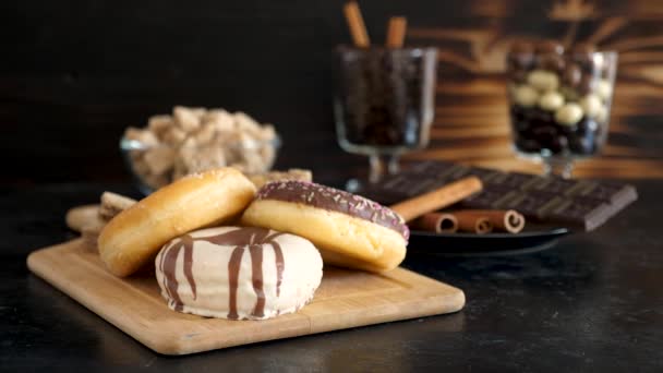 Sweet and declicious donuts on a wooden board — Stock Video